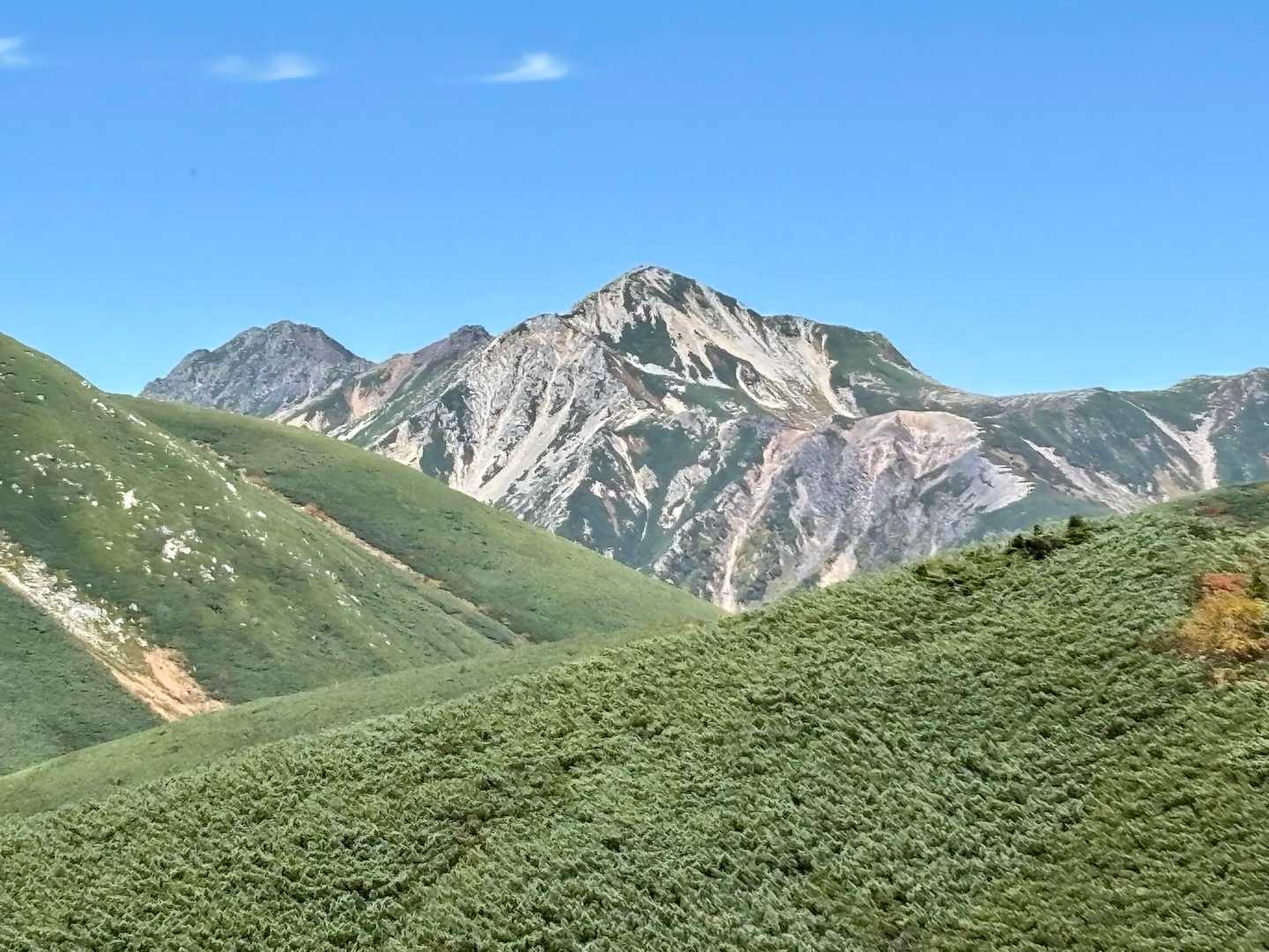 双六岳 | なだらかな山頂の彼方にそびえる槍ヶ岳の鋭峰は人気の絶景・天空の滑走路の写真