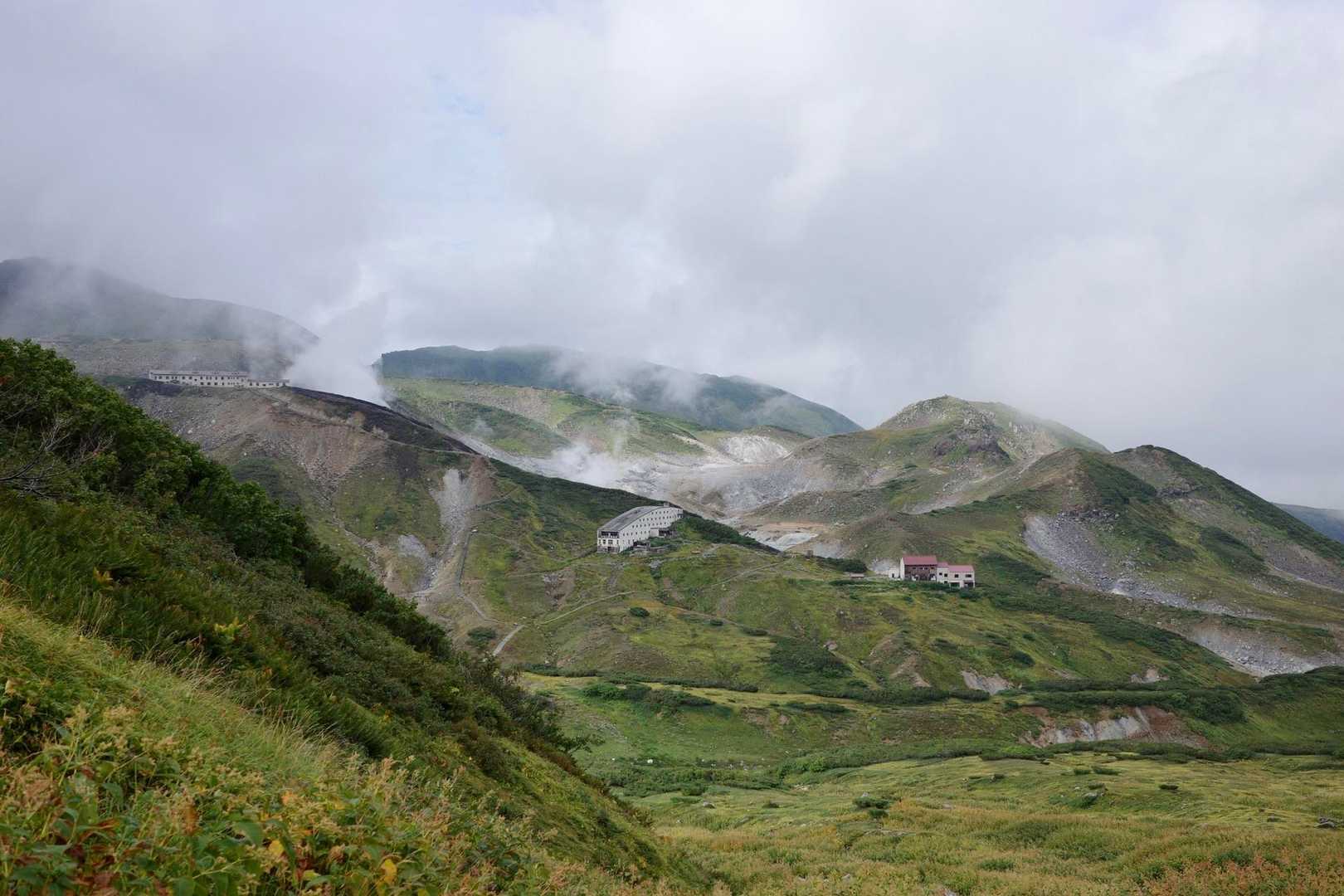 次々と湧き上がる新鮮な雲のあいだに、赤い屋根のロッジ立山連峰や白い雷鳥沢ヒュッテが見える