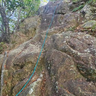 岩をよじ登り