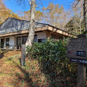 無人の建物と奥にトイレと案内板があります。