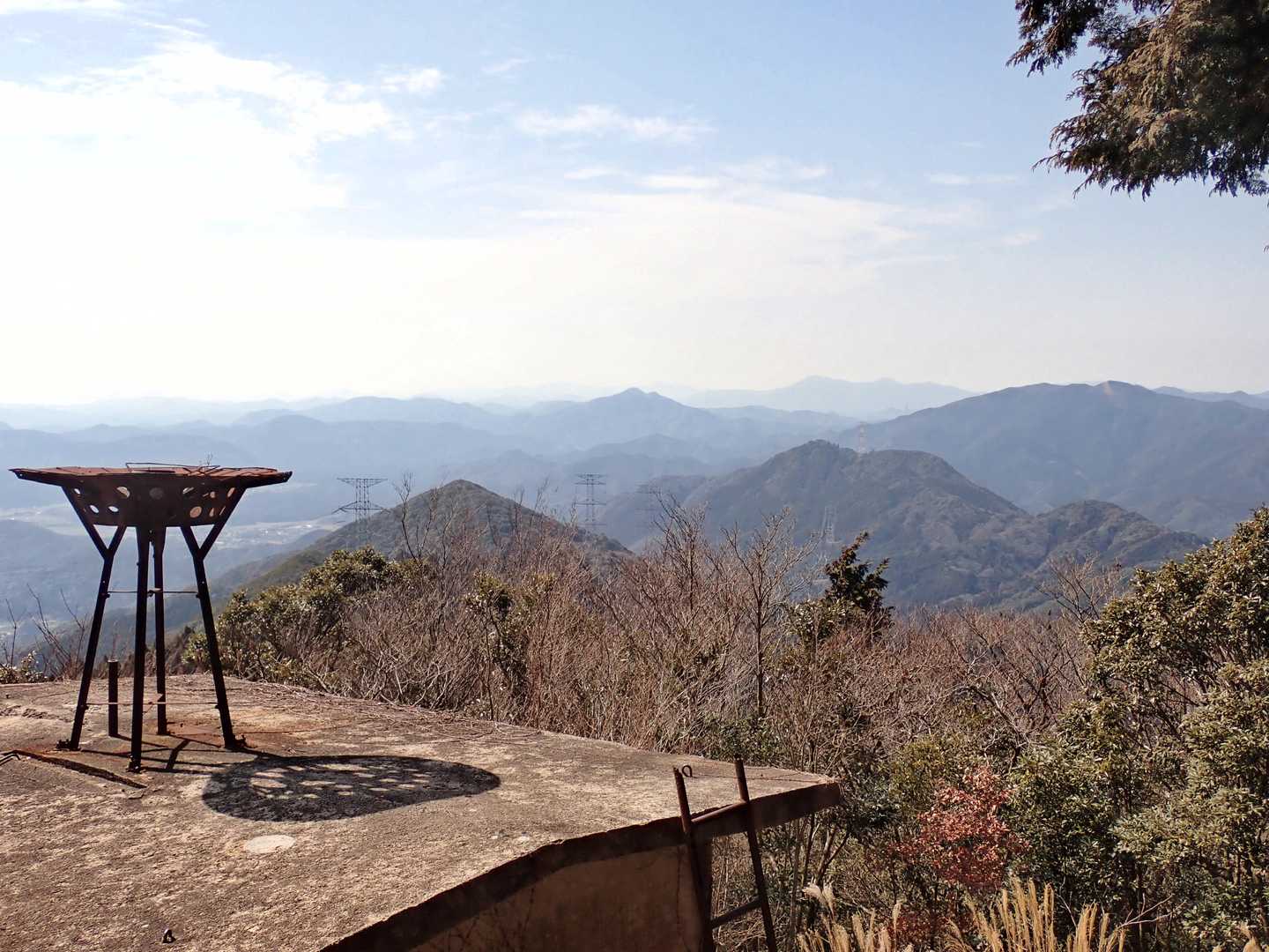 西方面の展望。手前から如意ヶ岳、花尾山、雁飛山、華山、北浦スカイラインなど。左の建物は雨量計小屋の跡です。