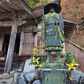 月輪寺に立つ親鸞聖人像と本堂
