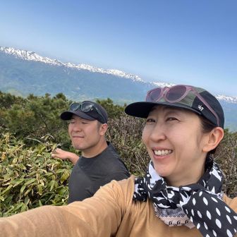 雪の残る山並みをバックに