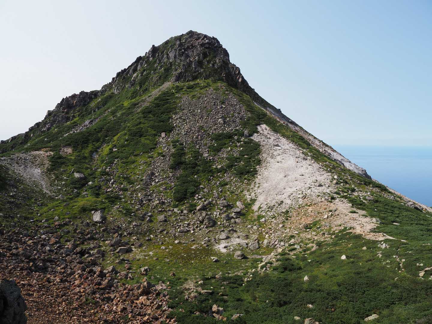 硫黄山の頂上の麓です。写真右側を登ります。岩々ですがマーキングされていますので、周りを確認すれば登りやすいルートが見つかります。