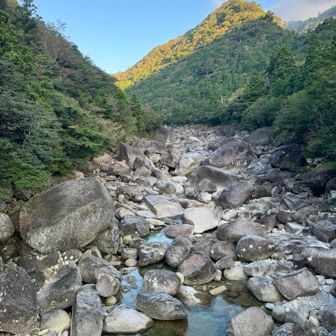 橋の上から巨石と透明度が高い川と青空