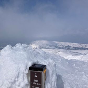 山頂シンボルの後ろに横岳