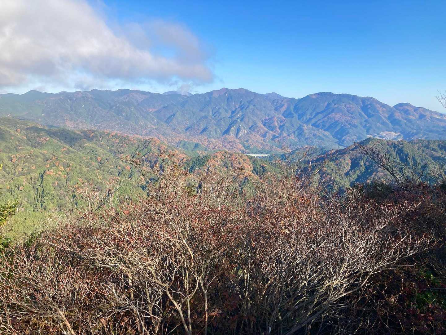 明星ヶ岳西峰が最も眺望があります。
鈴鹿南部の山々が一望です。
右から、鉄塔も見える野登山、トンガリ頭の鎌ヶ岳とその左の御在所岳、中央には仙ヶ岳の双耳峰、少し雲にかかっている雨乞岳、御所平の左奥には綿向山も見えます。