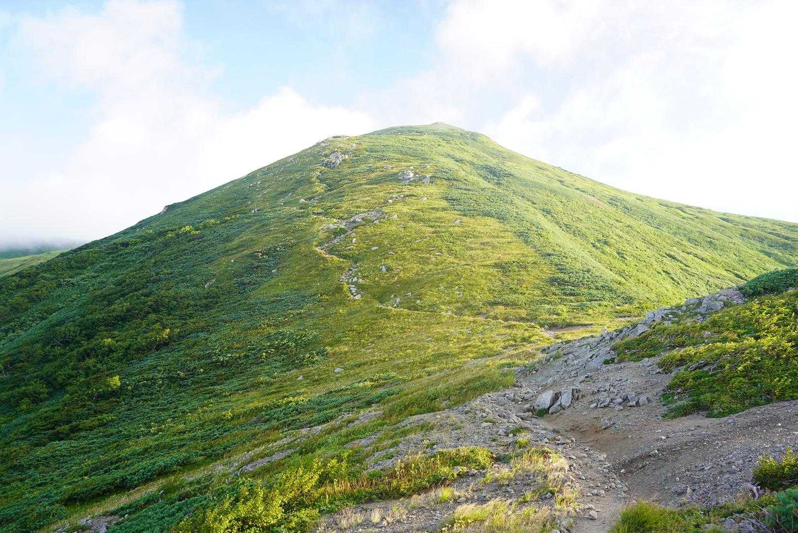 飯豊山往復 | 長き旅路の果てに現れる天空の主稜線、万年雪と高山植物が咲き乱れるの写真