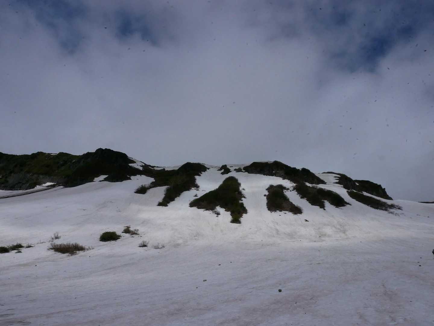 左上に高根ヶ原を見ながらどこまでも続く雪原を進みます。すべるのでアイゼン装着しました