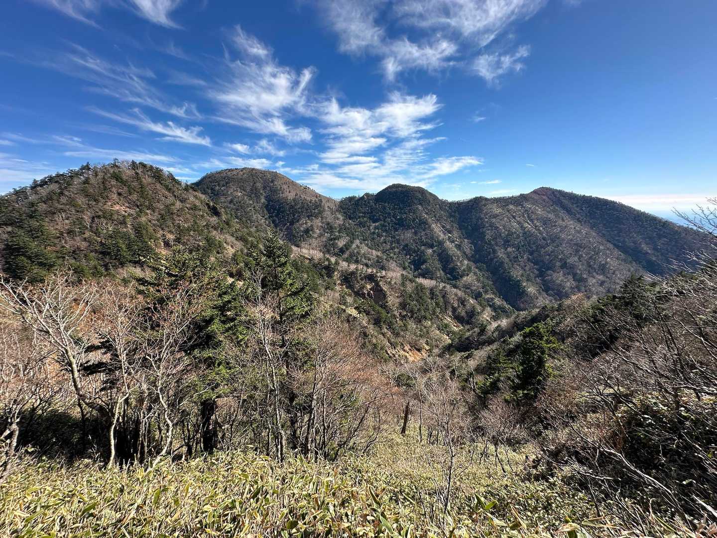 稜線の分岐に出ました。
釈迦ヶ岳は左から２番目のピーク、３番目は剣ヶ峰です。
釈迦ヶ岳に行くためには鶏頂山から一度、標高差150mくらいを下り、見えている一番左のピークを越えて200mくらいを登ることになります。
地元の方でしょうか、80歳前後のソロの男性登山者とお話しして、いろいろ教えていただきました。我々は、何歳まで山歩き出来るだろう