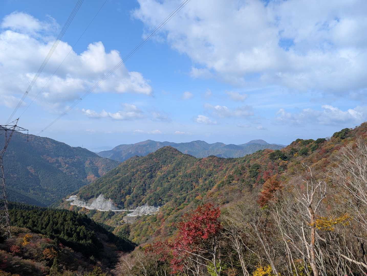 ⛰️西側の眺め。
滋賀県・多賀町方面へと抜ける国道306号線が、山腹に張り付くように通っています。
最奥の山並みの、左肩から緩やかに上がってきて少し尖ったピークが高室山、右端の台形の山容が鍋尻山です。