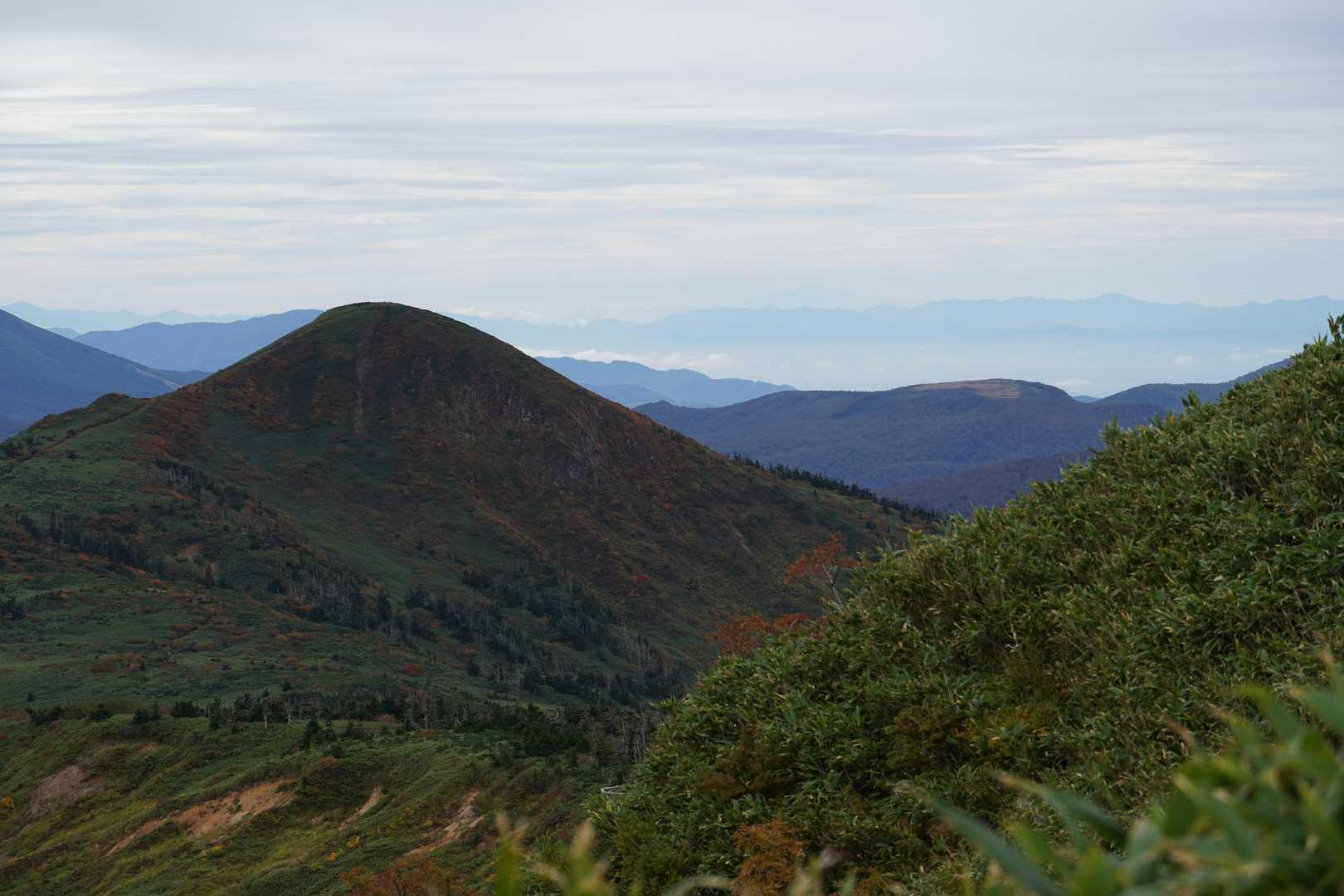畚岳・曲崎山の間、後方に薄く月山