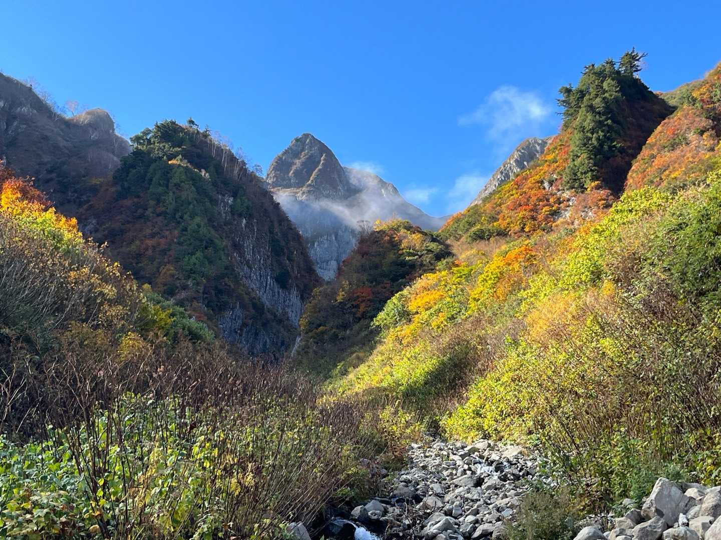 荒菅沢出合まで降りて来ると山頂付近に雲が湧き始めました⛅️

紅葉と青空に挟まれて、白いネックゲーターをまとった雨飾山がかっこいい！⛰️🍁✨