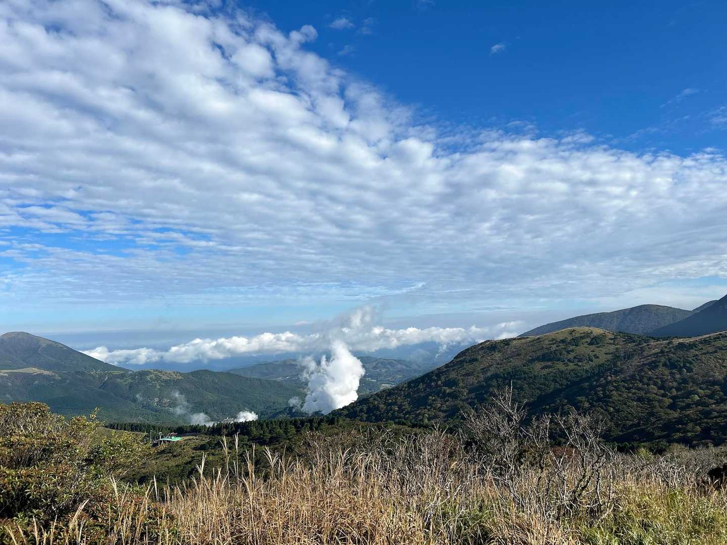 合頭山・猟師岳 | 山頂からミヤマキリシマで色鮮やかな星生山、三俣山の山腹を望むの写真