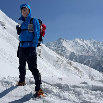 ワタクシも這々の体でなんとか大ノマ乗越の稜線に登りあげて、先に着いて休憩をしていたオニーサンに槍ヶ岳をバックに撮って頂きました📸
この日はほぼ無風で無茶苦茶暑かったです🥵
なのにフードを被っているのは、日焼け止めを塗らないワタクシの耳と首の日焼け対策です😅　この薄手のソフトシェルの下は長袖の化繊ロンT１枚だけです💦
担いできたアイゼンとピッケルはこれだけグズグズの雪では何の役にも立たず、ただのザックのおもりでした😆