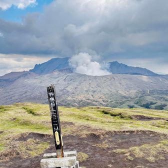 山頂碑の背後に阿蘇中岳の噴火口。