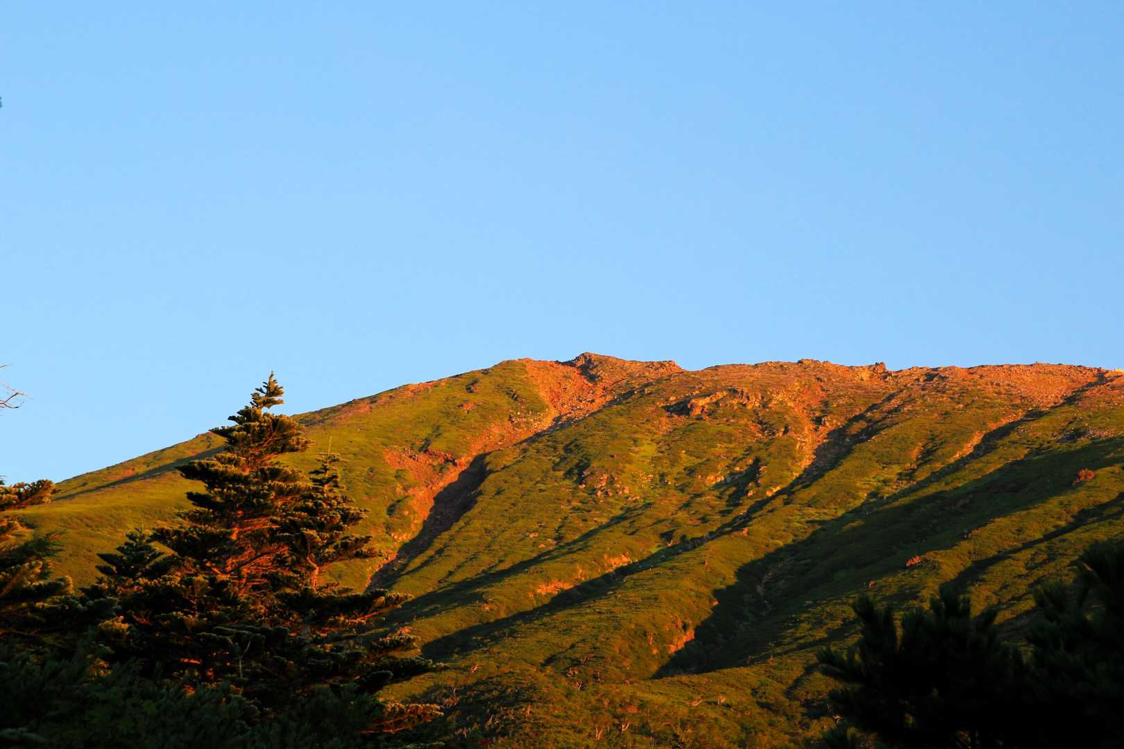 朝日に照らされ、御嶽山がオレンジに輝いています。