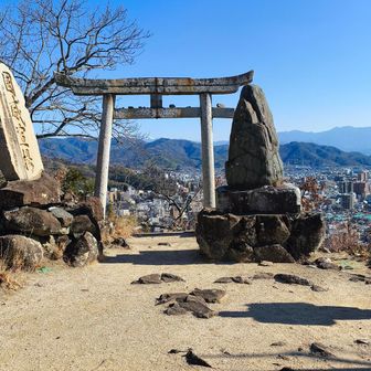 頂上には、天空の鳥居？が。鳥居の向こうには雪を湛えた石鎚系山脈がかすかに見える。堂ケ森かなあ？
それより、石碑倒れそう。
ここは、石鎚神社の遥拝所だそう。ということで、見えないけど石鎚山頂を向いて建てられているのでしょう。