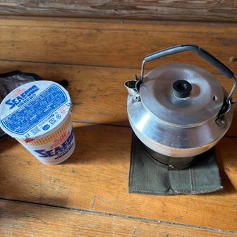 山頂付近は風速10mくらいの強風で吹きさらしだったので避難小屋までもどって昼餐