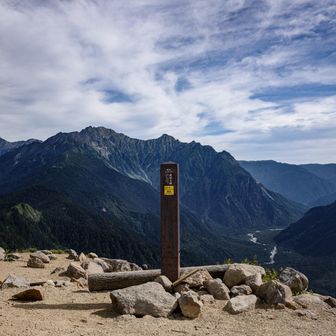 背景が壮観な山頂標識