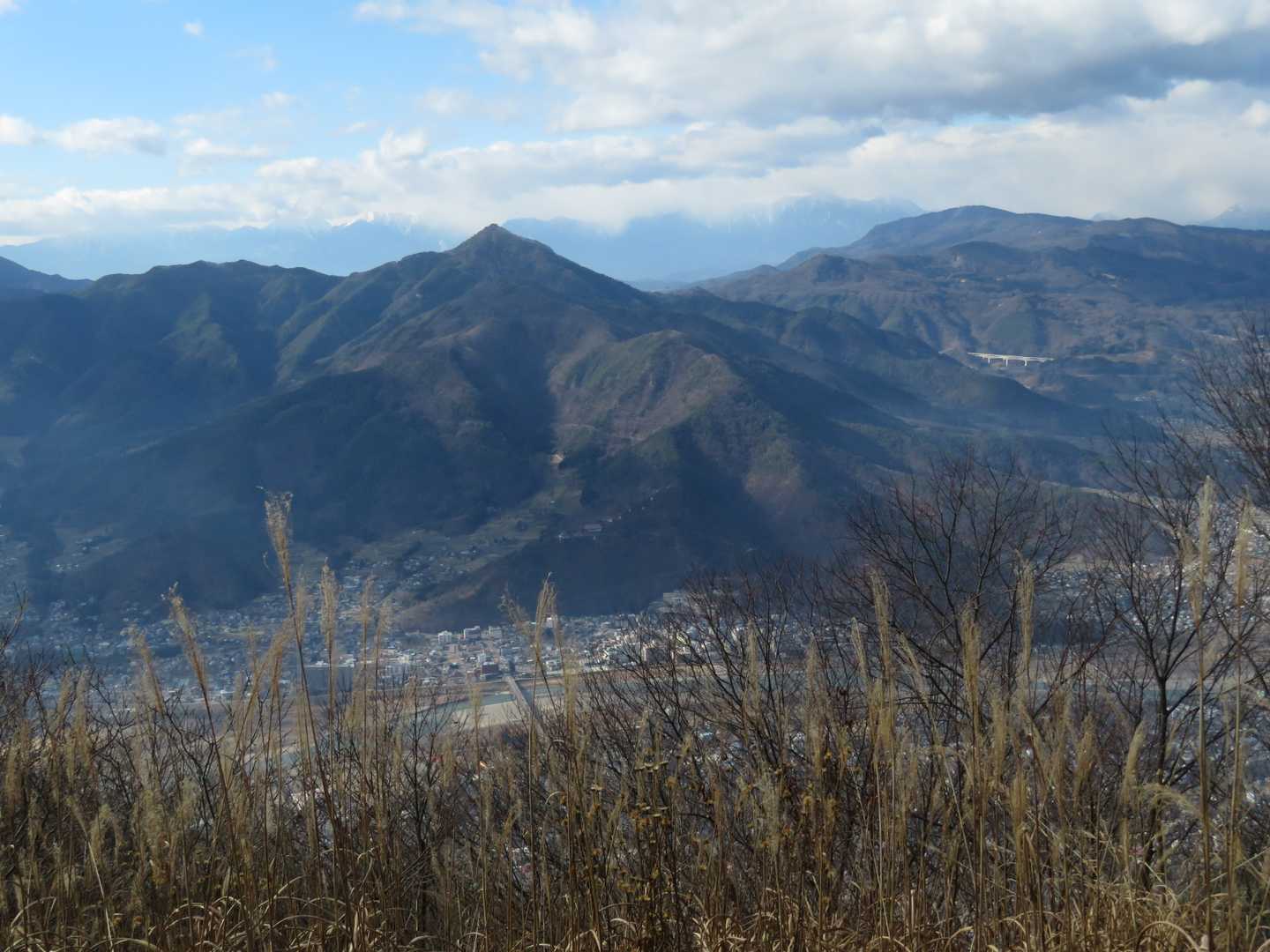 ピラミッド型の冠着山、右に聖山。聖山の下に長野自動車の橋が見えます。北アルプスはあまり良く見えません