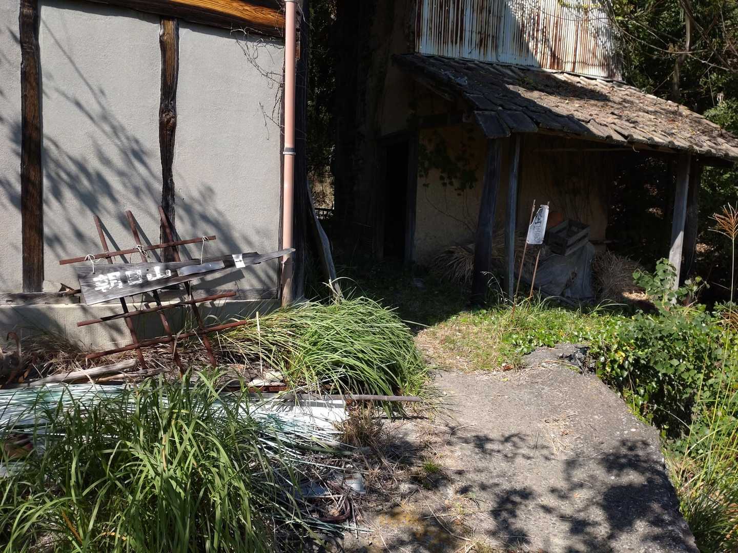 空家の前ですが、標識がこの家の間を通るよう示しています
