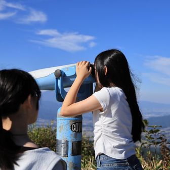 そしてクルマで寝ていたコチさん（下の子）が遅れて登場😆あまり絶景に興味のないコチさん、一目散に山頂備え付けの望遠鏡へ😂