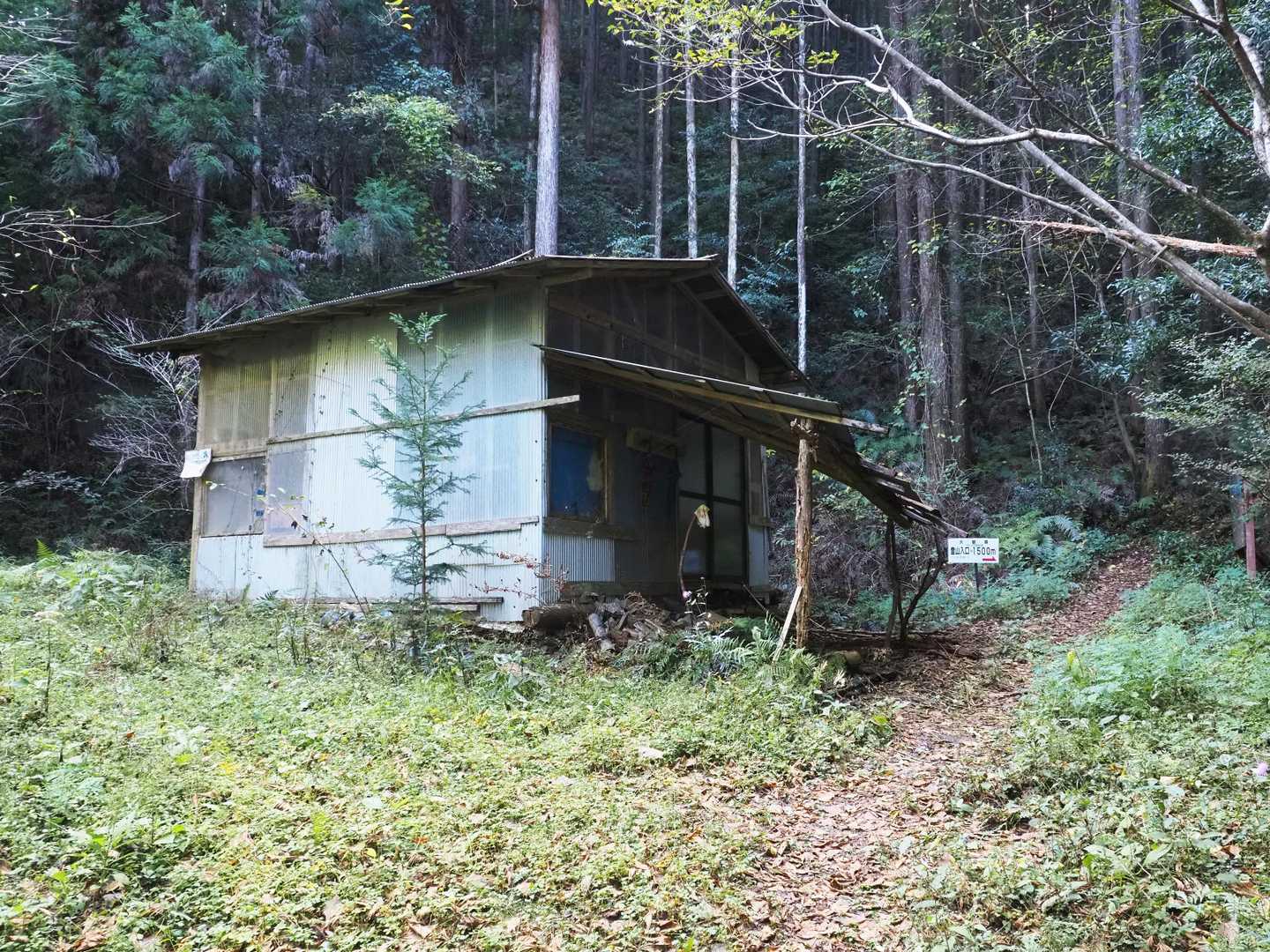 ゲートから400ｍほど林道を進んだところにある作業小屋
小屋の前を奥に
山頂まで1500ｍの標識がある