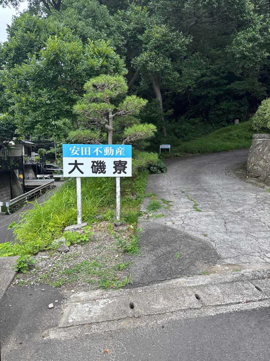 こちらが寮の門の左側、奥に見える小さな看板🪧が登山口です。
