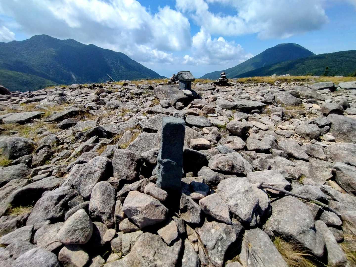 それでも前に進まねばならぬ身、南峰にある廃止四等三角点を中央に北横岳と蓼科山。更に中央を遠望すれば、諏訪湖の向こうに守屋山も見ゆる⛰️