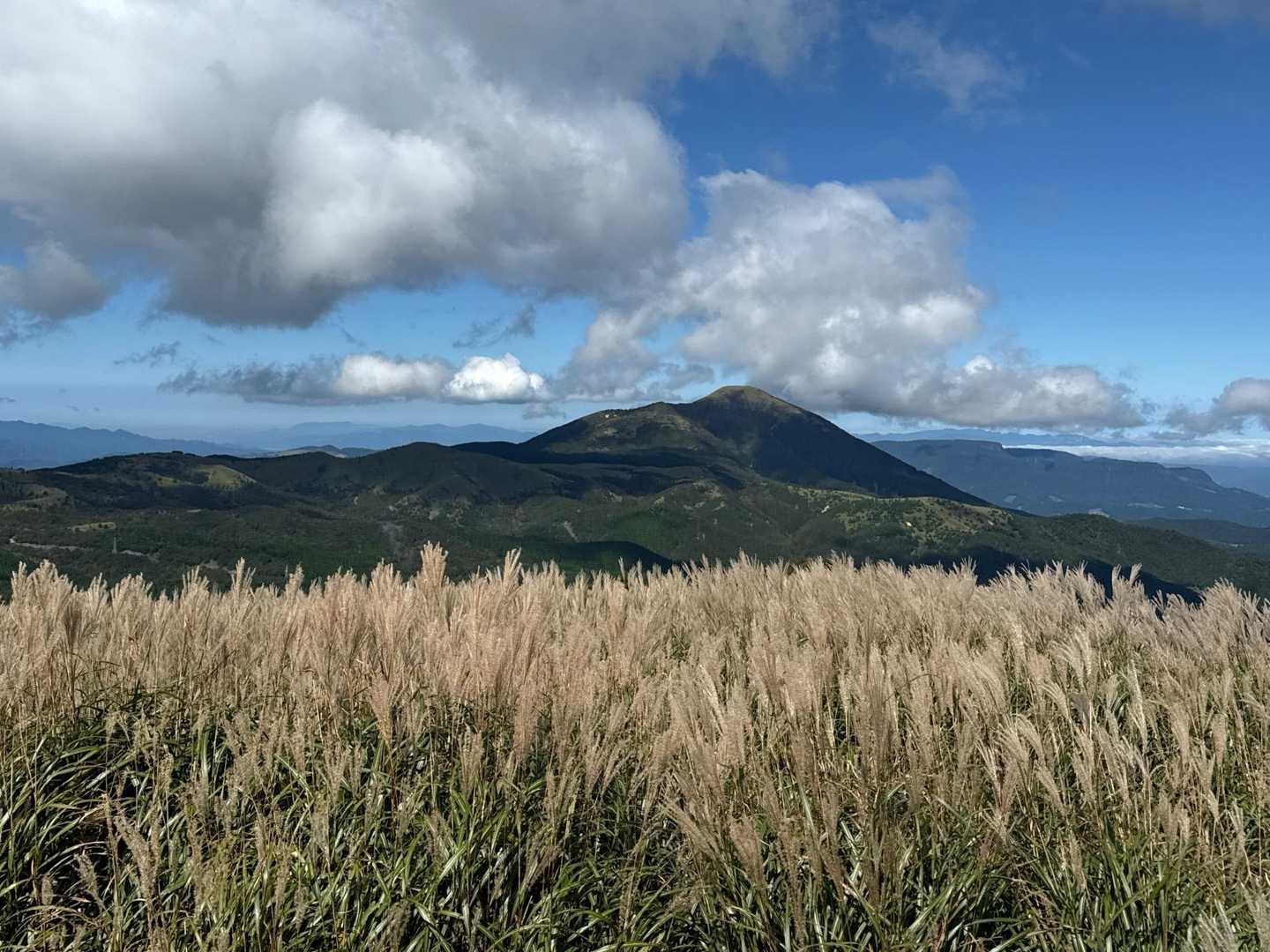 合頭山・猟師岳 | 山頂からミヤマキリシマで色鮮やかな星生山、三俣山の山腹を望むの写真
