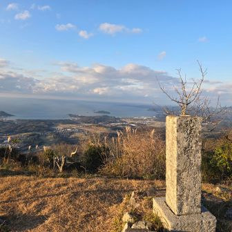 碑の向こう側の山に風車群が見えている👀