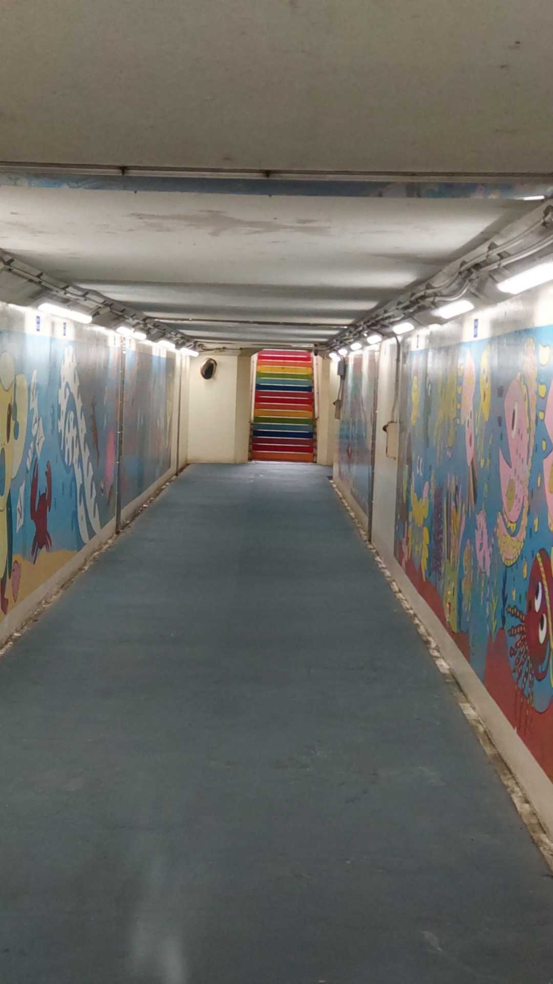 駅前の地下通路。明るくて壁には小学生のイラストが。階段が虹色🌈✨