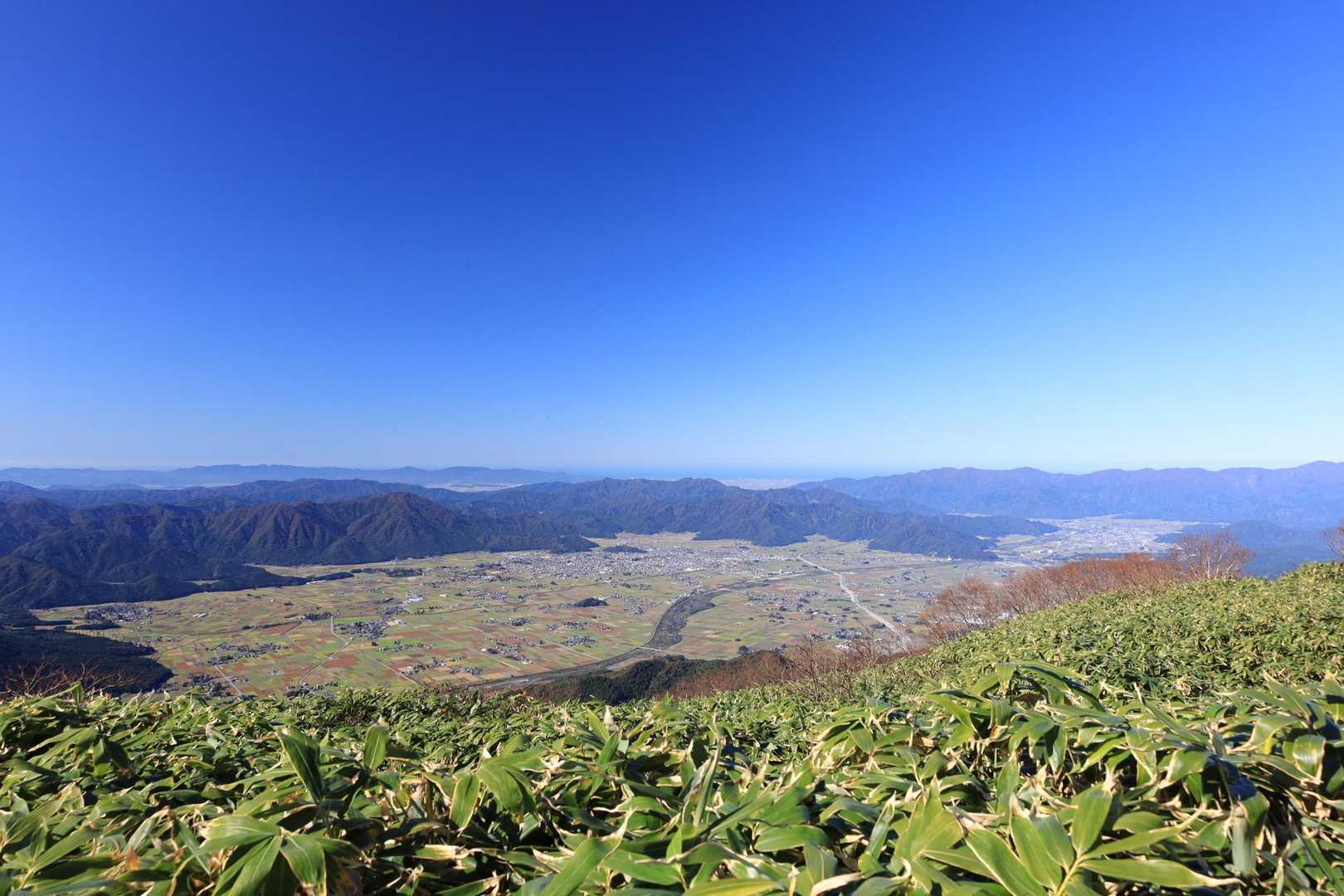 山頂からの大野盆地
水田がパッチワークみたい

中央の島のような亀山に
越前大野城が聳えてます

遠く日本海まで見えてます