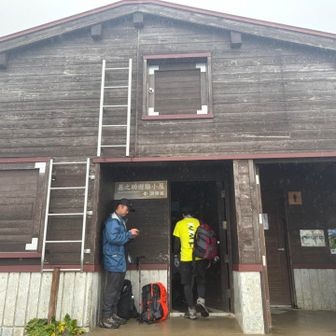 立派な避難小屋。人がいっぱい。汗を拭く。