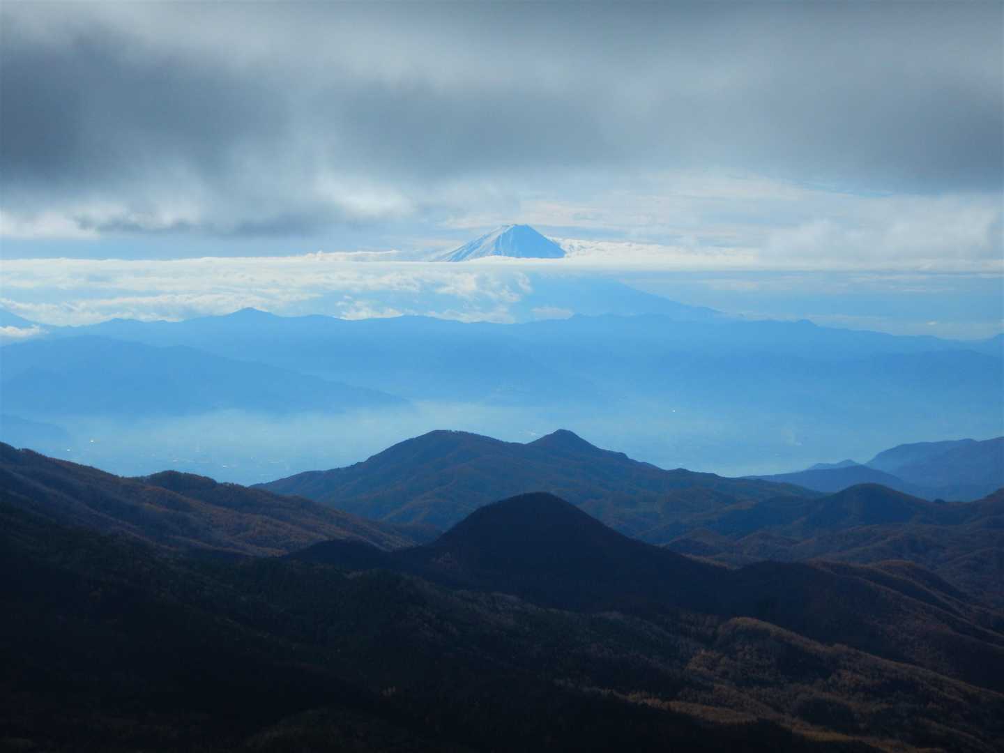 雪化粧した富士山が雲の中にぽっかり
