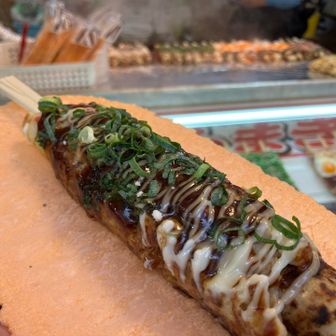 関東ではあまり見かけないハシマキという食べ物。1本500円。
せんべいの皿にのっけて提供されます。
🐙が入ってない棒状のタコ焼きみたいな食べ物でした。美味しかったけど具材を考えると500円は微妙か。