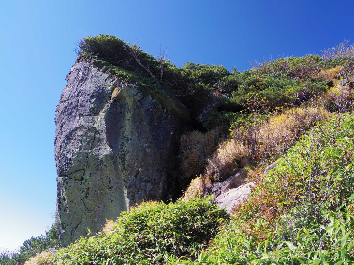 岩を手で掴みながらよじ登っていく
山頂横に突き出た奇岩