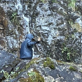岩と同化する上着を着た女神