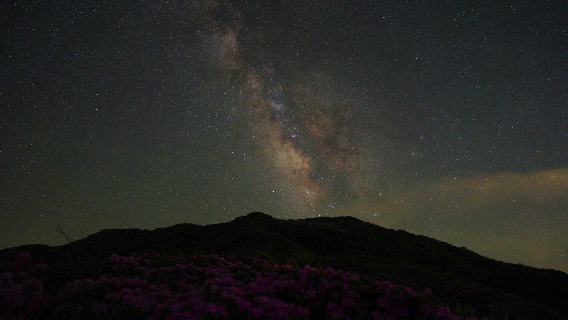 月明かりのない夜空に輝く天の川と烏帽子岳。