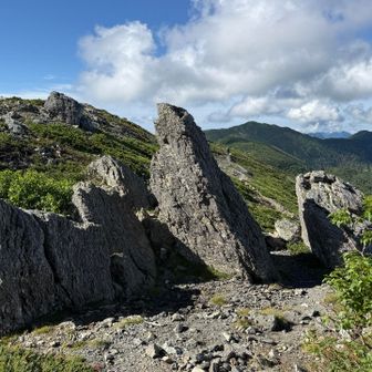 草原の道を歩くと、褶曲山地らしいシンボルの岩。