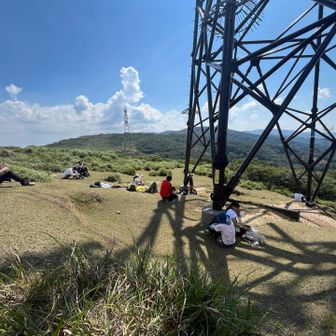 鉄塔、休憩。この鉄塔の高圧電線がのちに我々を苦しめることになるとは…