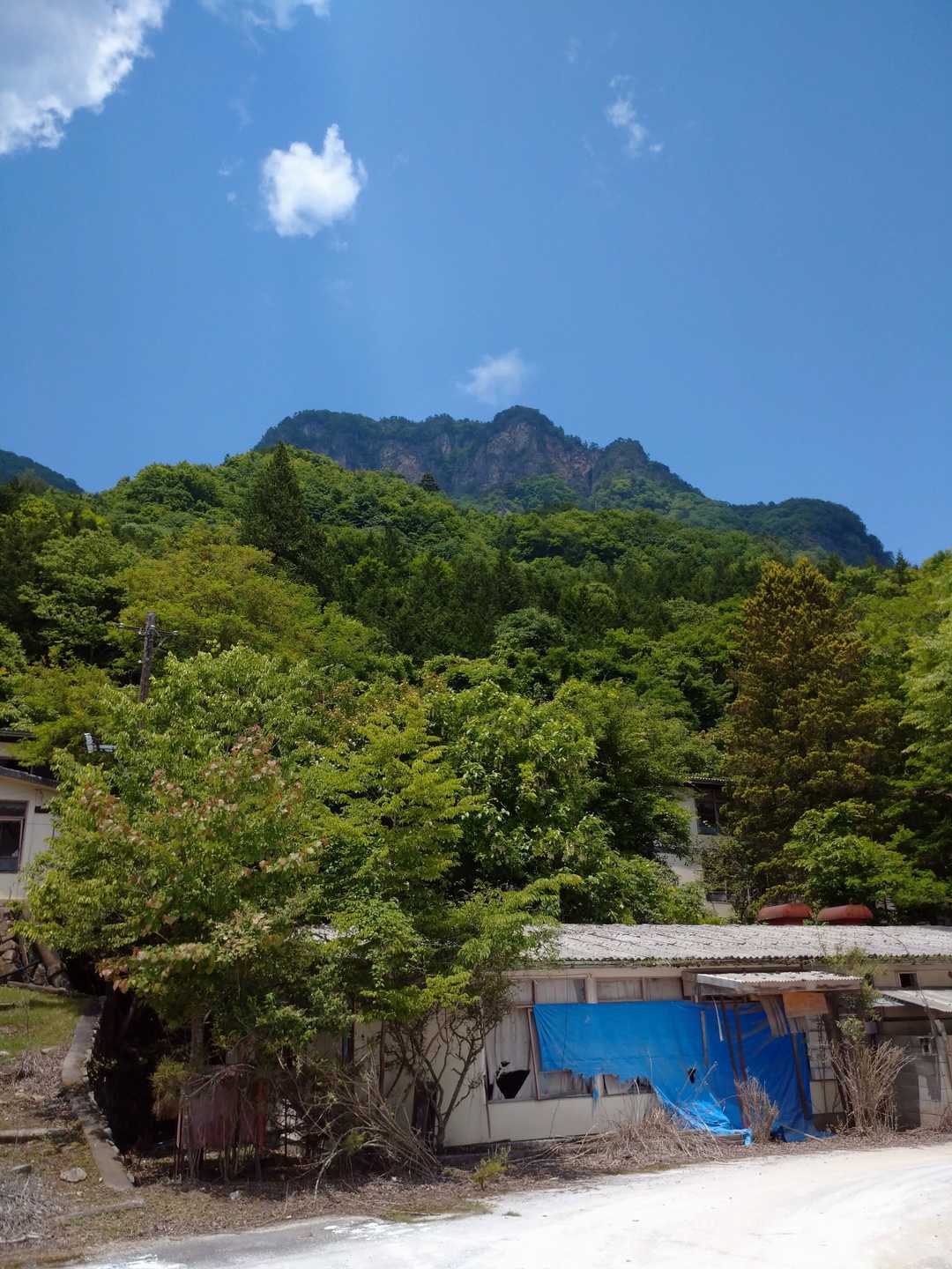 廃屋の裏に赤岩岳が見えます。