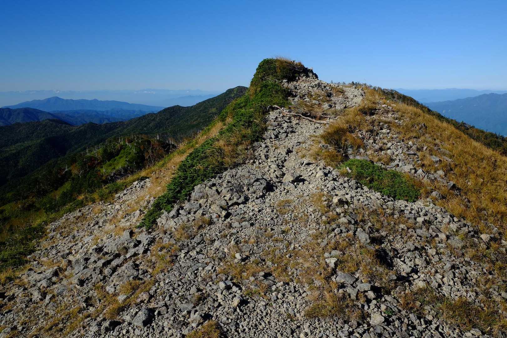 白根隠山山頂からちょっと進んだところ。正面のピークの向こうはとても崩れやすい急坂になってます。下りでは危なそうだったので左斜め後ろからのびてる巻道を使いました