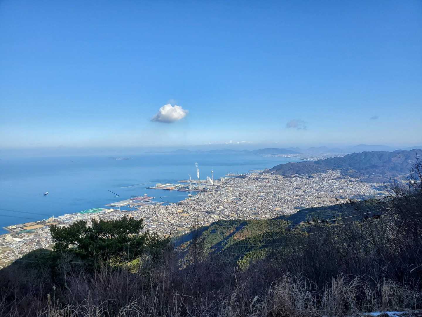 展望台からの四国中央市市街です。煙突からの煙は真っ直ぐです。
向こうには紫雲出山がある荘内半島や伊吹島が見えます。また天空の鳥居で有名な稲積山がある七宝山山系も見えます。