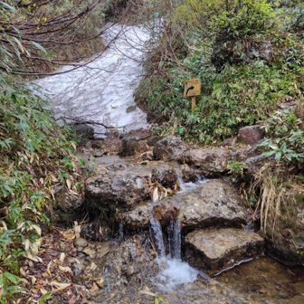 祓川の雪解けと”これから急坂”の看板