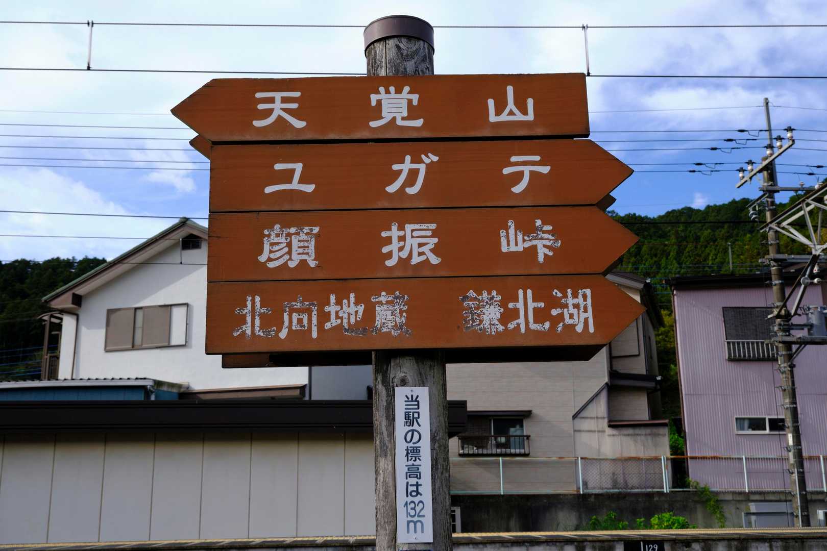 なお、此度の山行に当たってはYAMAP登山地図の『ヤマノススメ巡礼マップ(天覚山・大高山・子の権現)』を利用させていただいていることもあり、本作劇中の描写に沿った解説も加えていくこととしたい。
写真は『東吾野駅』前に立てられた登山者向けの道標。アニメ版では、主人公がこれを確認した際、『ユガテ』って何？と首をかしげる一幕が。『ユガテ』とは『天覚山』とは反対方向の『越上山(おがみやま、566m)』や『鎌北湖(かまきたこ)』へ向かう道程で通る山間の集落の名で、春季には花々の彩りで素晴らしい景色を楽しめるそうな。