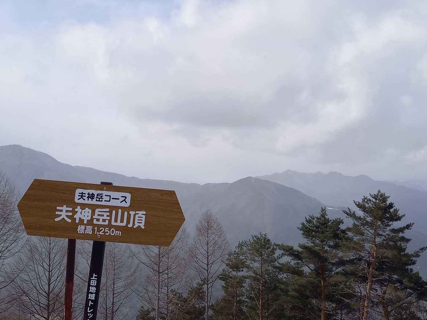 北西から雪雲が流れてきます。看板の右後ろが十観山。たぶん。