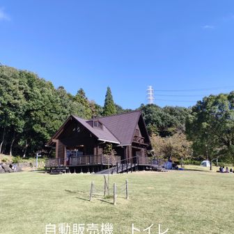 ログハウスに自動販売機　トイレ　机と椅子あり　ログハウスは扉なし