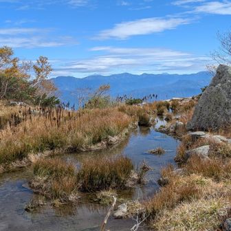 濃ケ池の水が流れ出す川と南アルプス。